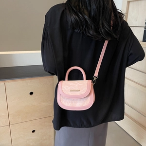 Pink saddle bag with marble texture flap and gold metal bar shown on model back