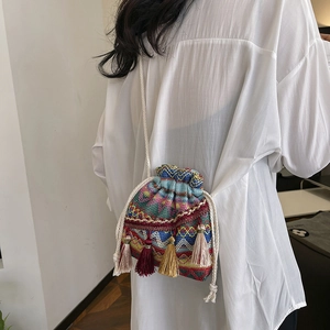 Sac seau ethnique brodé avec motifs géométriques colorés et pompons décoratifs chic