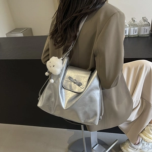 Minimalist silver metallic tote bag with bow detail and cloud charm shown on model