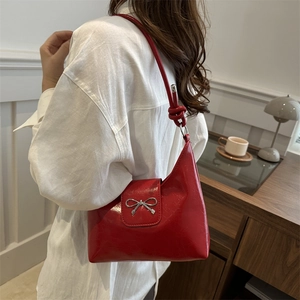Stylish red glossy underarm bag with silver bow accent and asymmetrical half-moon shape