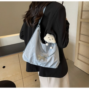 Detail of blue marble texture tote bag with butterfly charm and fluffy cloud pendant
