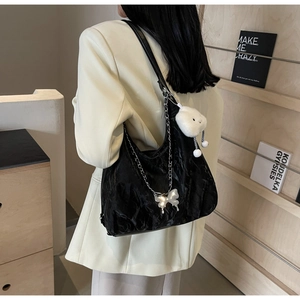 Detail of black pleated tote bag with silver butterfly and white plush cloud charms