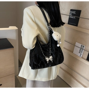 Close-up of black pleated tote bag with silver chain and white plush cloud charm