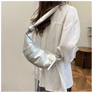 Chic silver dumpling bag featuring unique ruched details and a stylish knotted shoulder strap