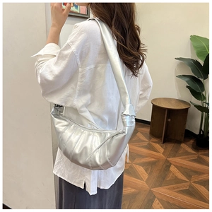 Detail of metallic silver dumpling bag with pleated texture shown in a lifestyle setting