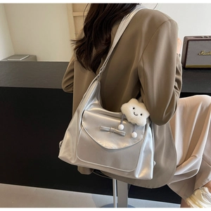 Silver matte shoulder bag with a bow detail and a plush white cloud charm attached