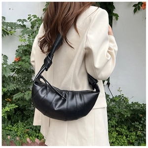 Detail of wide shoulder strap with knot and premium matte black leather texture