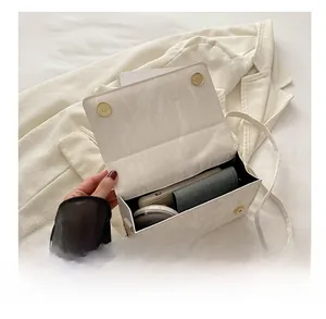 Interior view of white crossbody bag showing storage for phone, wallet and cosmetics
