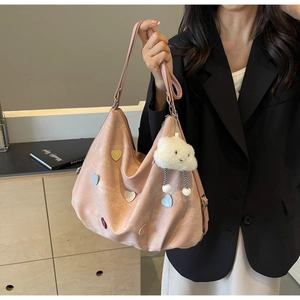 Détail du sac bandoulière rose mat avec écussons cœurs colorés et gri-gri nuage
