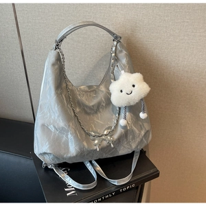Detail of silver pleated leather hobo bag with metal chain and plush cloud charm