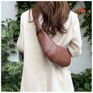 Detailed back view of a brown leather croissant bag with knotted wide shoulder strap