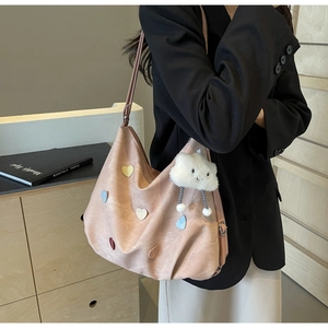 Détail du sac cabas rose avec écussons en forme de cœur et pendentif nuage doux