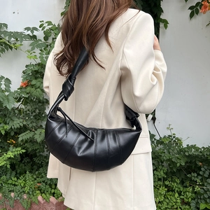 Minimalist black pleated croissant bag with adjustable knotted wide shoulder strap for women
