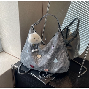 Détail du sac cabas en denim gris avec écussons cœurs colorés et breloque nuage