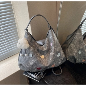 Détail du sac cabas gris texturé avec écussons cœurs colorés et breloque nuage