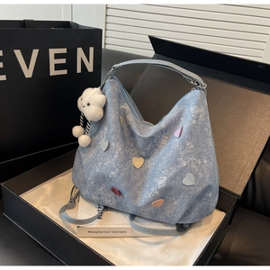 Vue détaillée d'un sac cabas en denim bleu clair avec écussons cœurs et charme nuage