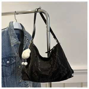 Dettaglio borsa hobo in pelle stropicciata nera con charm a nuvola e tracolla regolabile