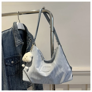 Dettaglio della borsa hobo con texture marmorea e ciondolo a nuvola di peluche