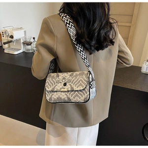 Détail d'un sac bandoulière rétro avec sangle tissée dans le décor d'un café moderne
