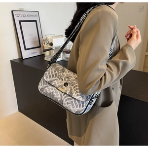 Détail d'un sac bandoulière à motif de vagues avec une large sangle jacquard géométrique