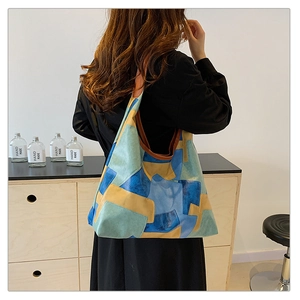 Macro detail of a large geometric patchwork tote bag with vibrant blue and yellow color blocks