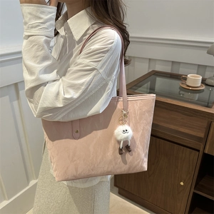 Rosa Tote Bag mit Wolkentextur und Plüsch-Anhänger getragen von Model im Café