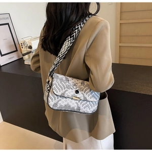Vue détaillée d'un sac bandoulière vintage aux motifs de vagues noirs et blancs et fermoir