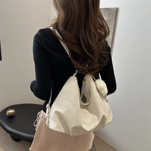 Grande borsa tote beige minimalista con trama a pieghe morbide e ciondolo morbido