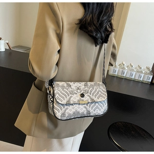 Détail du sac bandoulière avec motif de vagues noir et blanc et sangle géométrique
