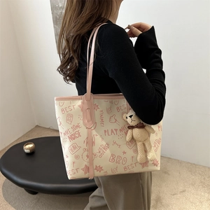 Chic beige tote bag with pink graffiti prints, slim straps and a cute bear charm pendant