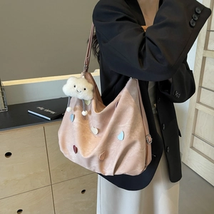 Grand sac hobo rose avec patchs cœurs colorés et peluche nuage porté par un mannequin