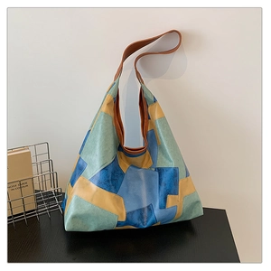 Detail view of large patchwork leather tote bag with vintage blue yellow and green colors