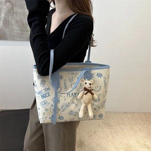 Borsa tote beige alla moda con stampe graffiti blu e ciondolo a forma di orsetto
