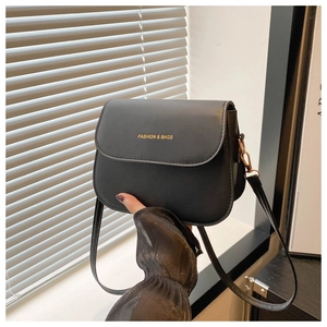Close-up of black leather crossbody bag with gold Fashion & Bags lettering and metal hook