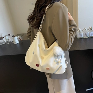 Grand sac cabas crème avec cœurs colorés et breloque nuage porté par un mannequin