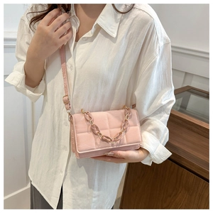 Detail of pink quilted flap square bag with gold hardware and chain handle
