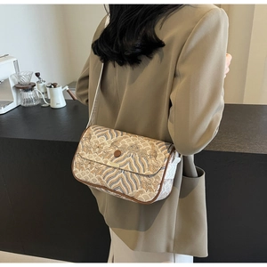 Détail d'un sac bandoulière rétro avec garniture en cuir et large bandoulière tissée