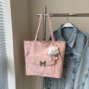 Detailed macro of pink nylon tote bag with silver butterfly buckle and cloud charm