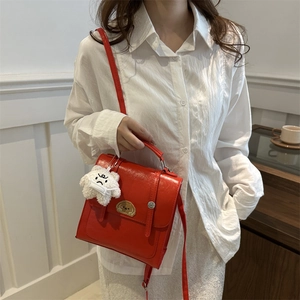 Retro red PU leather backpack for women featuring golden emblem and plush cloud charm