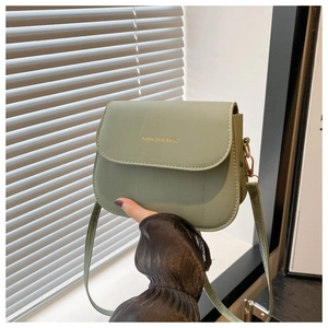 Detail of light green leather crossbody bag with FASHION & BAGS gold lettering