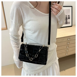 Close-up of black quilted leather square crossbody bag with chunky chain detail