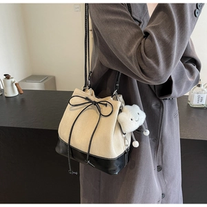 Detail of herringbone canvas bucket bag with black leather trim and cloud charm