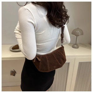 Détail du sac à main marron foncé en suède brossé avec bandoulière à nœud décoratif