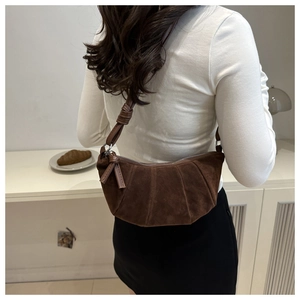 Détails du sac croissant en daim marron foncé avec texture plissée et bandoulière nouée