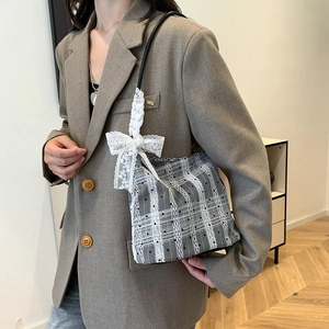 Chic grey checkered bucket bag with delicate lace bow detail and black shoulder strap