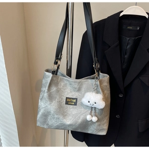 Détail du sac cabas gris avec logo MiaTmait et charmant pendentif en peluche nuage
