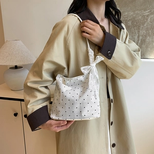 Elegant white polka dot bucket bag with lace trim and large bow for modern women