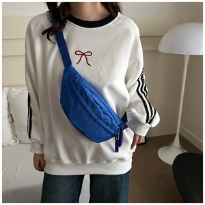 Detail of the blue nylon chest bag with adjustable strap and braided zipper puller