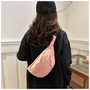 Pink casual crossbody chest bag with woven zipper pulls and black plastic buckle detail