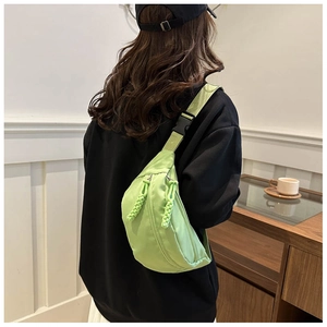 Detail of avocado green nylon crossbody bag with braided rope zipper and buckle strap